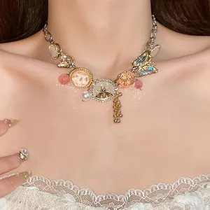 Detail of a chunky pendant necklace with butterfly and bee charms worn on the neck