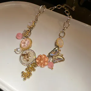 Detailed close-up view of an elaborate statement necklace with crystal bee and butterfly charms