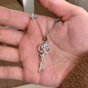 Exquisite stainless steel key and star pendant necklace featuring sparkling cubic zirconia stones