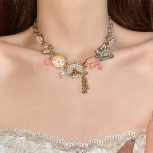 Detailed macro view of a vintage crystal pendant necklace featuring bee and butterfly charms.