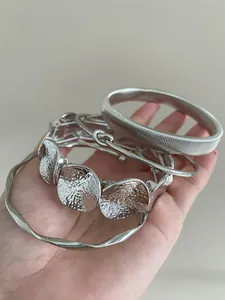Detailed shot of stackable silver geometric metal bracelets with irregular textures