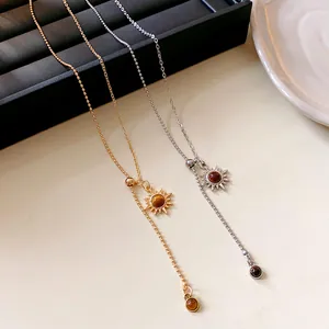Nahaufnahme von Vintage-Sonnenanhänger-Halsketten mit künstlichem Tigerauge in Gold und Silber