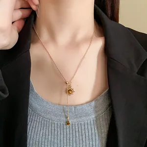 Elegante Vintage-Sonnenanhänger-Lariat-Halskette mit künstlichem Tigerauge-Stein auf Modell