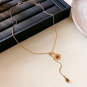 Detailansicht einer goldenen Sonnenanhänger-Halskette mit künstlichen Tigeraugen.