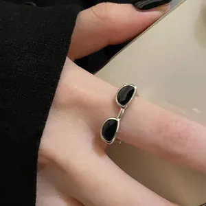 Primo piano di un anello aperto creativo a forma di occhiali con smalto nero rifinito