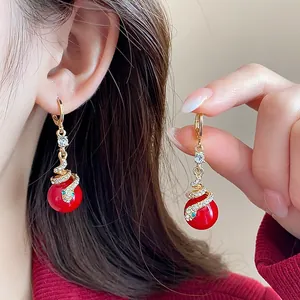 Detail of gold snake earrings with red pearls and sparkling crystals for 2026 Year of Snake.