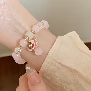 Handmade pink strawberry quartz beaded bracelet featuring a cute moon and cat charm.