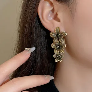 Vintage bronze floral tassel earrings on model showing retro aesthetic design