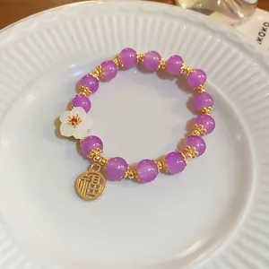 Detailed shot of handmade purple crystal beaded bracelet with gold Fu charm