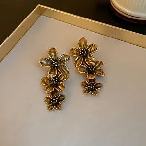 Close-up of vintage gold-tone flower earrings with tiered floral design