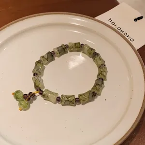 Detail of New Chinese style handmade bracelet with green bamboo-shaped beads and purple spacers