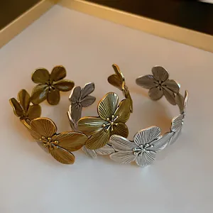 Detailed macro view of vintage floral open bangles with brushed gold and silver metal textures