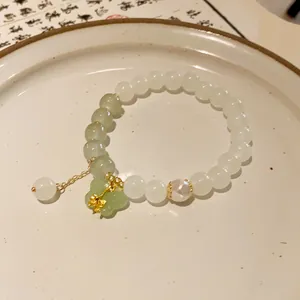 Close-up detail of handcrafted New Chinese style beaded bracelet with green butterfly charm