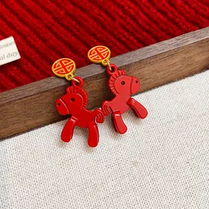 Detailed close-up of red enamel horse stud earrings with gold Chinese Fu character