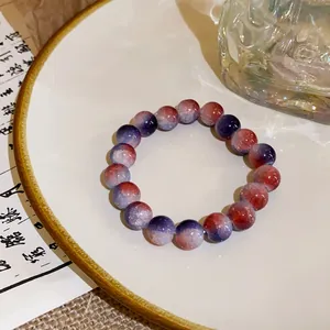 Close-up of handmade gradient crystal beaded bracelet on a white ceramic plate