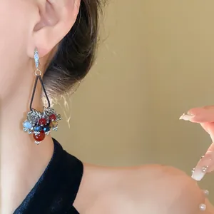 Close-up detail of Bohemian style zircon and glass bead drop earrings on model