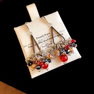 Detailed macro view of Bohemian vintage earrings featuring colorful beads and zircon hooks