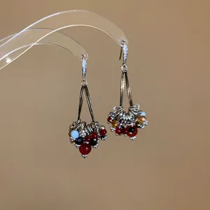 Detailed macro view of bohemian drop earrings featuring zircon hooks and vibrant colorful glass beads.