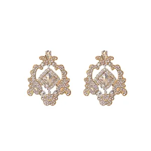 Vintage palace style gold earrings with geometric hollow patterns and clear rhinestones.