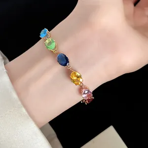 Vue détaillée d'un bracelet vintage doré avec des zircons ovales multicolores.