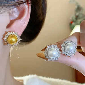 Detail view of elegant French style pearl earrings with sparkling zircon sunburst design.