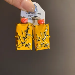 Close-up of New Chinese style yellow enamel square earrings with plum blossom design