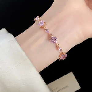 Vue rapprochée élégante d'un bracelet en zircon rose vintage sur poignet avec chaîne dorée