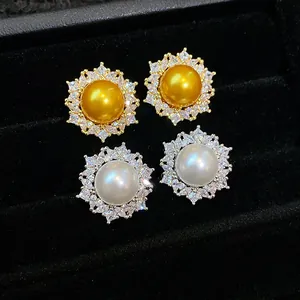 Macro view of French style gold and silver zircon pearl stud earrings in a jewelry box