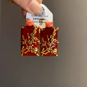 Detailed view of New Chinese style red enamel earrings with golden plum blossoms
