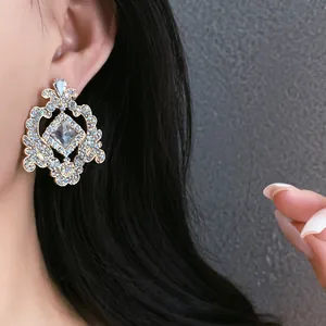 Close-up of French court style vintage geometric hollow earrings on model.