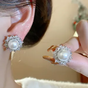 Detailed view of elegant French style pearl stud earrings with sparkling zircon halo design