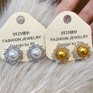 Close-up of elegant S925 silver stud earrings with white and gold pearls and sparkling zircon