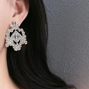 Close-up detail of ornate French vintage stud earring with hollow geometric pattern