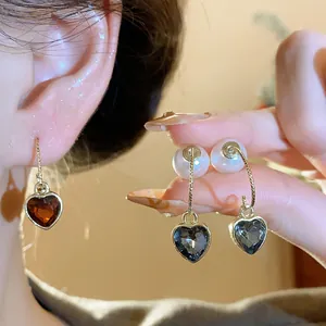 Close-up of vintage heart-shaped crystal earrings with pearl details for women