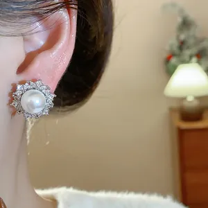 Close-up shot of an elegant French style silver needle zirconia pearl stud earring on ear