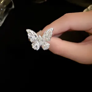Detailed close-up of a sparkling zircon butterfly ring with a high-shine silver finish.