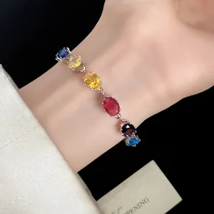 Gros plan d'un bracelet en zircon ovale multicolore au poignet avec un style élégant