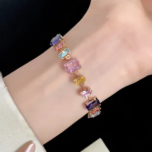 Gros plan détaillé d'un bracelet vintage en or orné de pierres de zircon colorées taille émeraude.