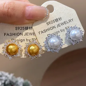 Close-up of elegant S925 silver needle earrings with pearls and sparkling zircons
