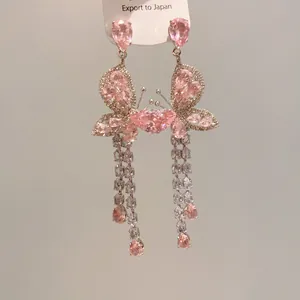 Close-up detail of elegant pink butterfly tassel earrings with sparkling zircons