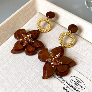 Detailed macro view of vintage brown floral dangle earrings with sparkling crystal centers