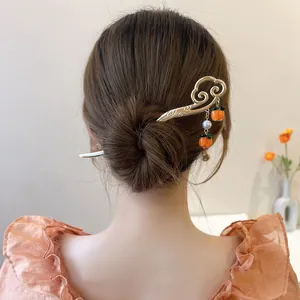 Close-up of elegant New Chinese style hairpin with persimmon charms in a bun.