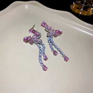 Close-up of elegant butterfly tassel earrings with sparkling pink cubic zirconia