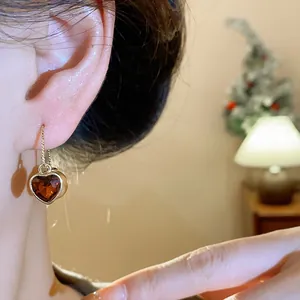 Close-up of a French vintage heart-shaped amber gemstone ear hook earring