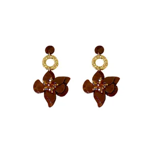 Elegant brown flower petal drop earrings featuring textured golden round metal rings.