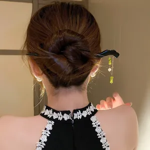 Elegant Chinese style hairpin with green bamboo tassels shown on a model's hair bun