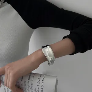 Λεπτομερές κοντινό πλάνο ενός μινιμαλιστικού ασημένιου ακανόνιστου βραχιολιού στον καρπό