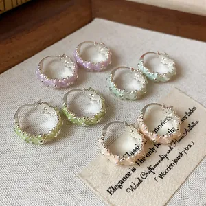 Detailed close-up showing pastel floral enamel hoop earrings with delicate metal accents