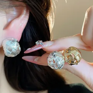 Dettaglio del design cavo intrecciato dei raffinati orecchini a clip placcati in oro 18k