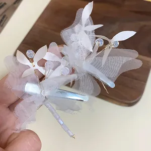 Gros plan d'une élégante pince à cheveux papillon en résille blanche et perles